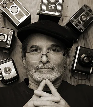 portrait of gerry pate with antique cameras in a circle around his face
