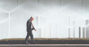 A pedestrian walks past fountains at Milliken during breezy sunny weather Monday..