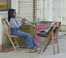 Teniquia Jackson 10, a fifth grader at Cleveland Elementary School in Spartanburg S.C. and a member of the schools band, practices her trumpet using a chair for her sheet music outside her Main Street home Tuesday November 13, 2001. Teniquia was having to play outside because  her practicing was a little loud in the apartment for her mom.(AP/Photo/Spartanburg Herald Journal/Gerry Pate)